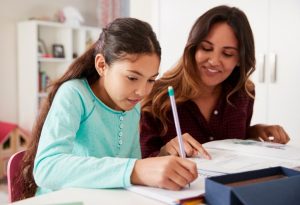 A child focused on writing homework with parental support and motivational elements visible