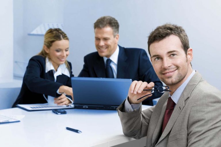 A businessman smiling and talking with colleagues in a professional setting