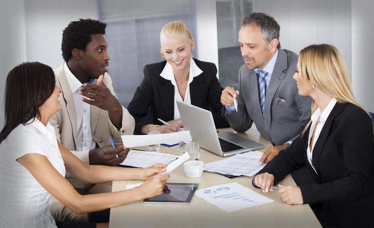 Business professional in formal attire working at a desk with laptop and documents