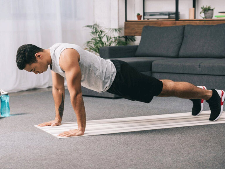 Man doing push-ups indoors, demonstrating strength and fitness exercise